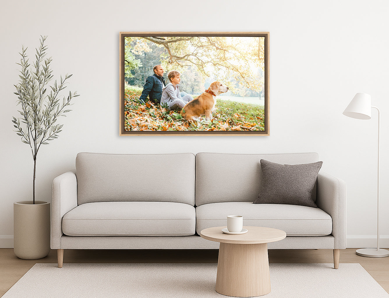 Living room with a gray sofa, round coffee table, and a framed canvas print of a couple and dog on the wall.