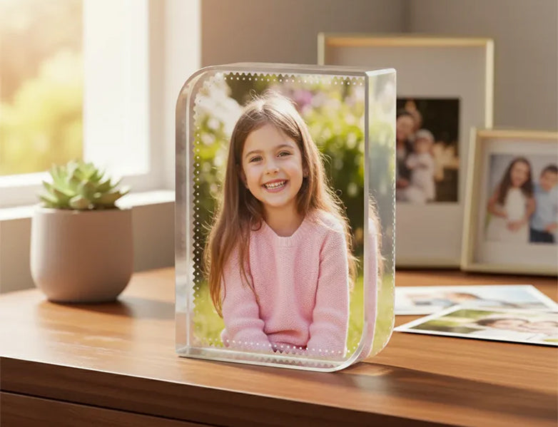 Clear photo frame with a young girl's smiling photo on a wooden surface.