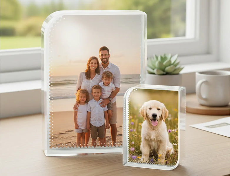 Two glass photo blocks personalised with family and pet images on a desk.