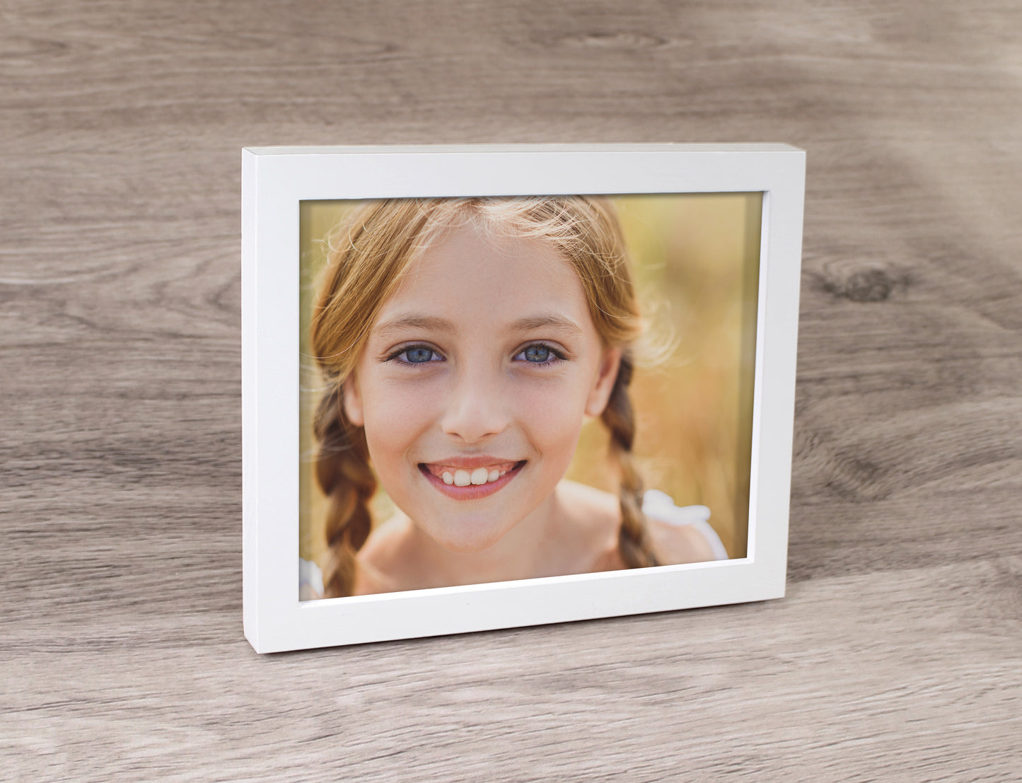 A white photo frame and a prints inside of a girl.