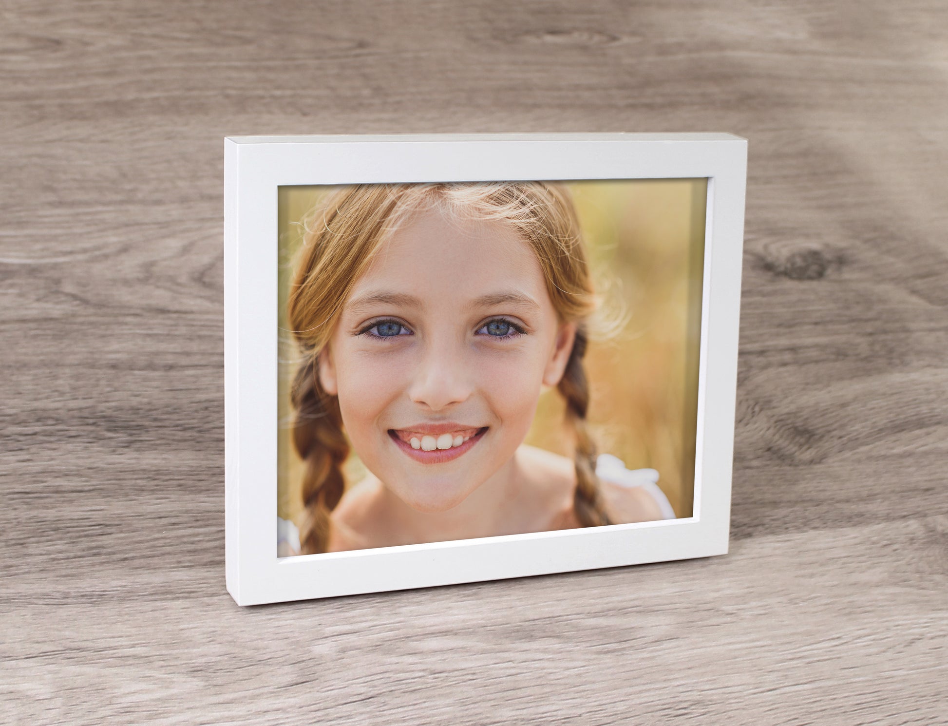 A white photo frame and a prints inside of a girl.