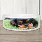 Custom ceramic pet bowl personalised with an image of a dog on it, placed on a wooden surface.